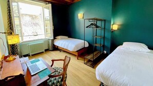 A room with two beds, a desk with a laptop, a chair, a radiator, and a window with curtains. - La Chocolaterie, Dream stay, Majestic view of the Chapelle Saint-Hubert (Unknown)