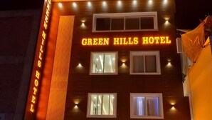 The exterior of the Green Hills Hotel with the name 'GREEN HILLS HOTEL' illuminated in neon lights. - GREEN HILLS HOTEL (Pithoragarh)