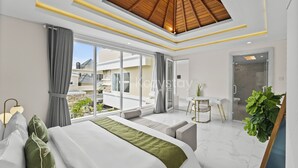 A modern hotel room with a large bed, a desk, and a view of the outside.