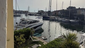 Marina com vários barcos atracados, cercada por edifícios e vegetação.