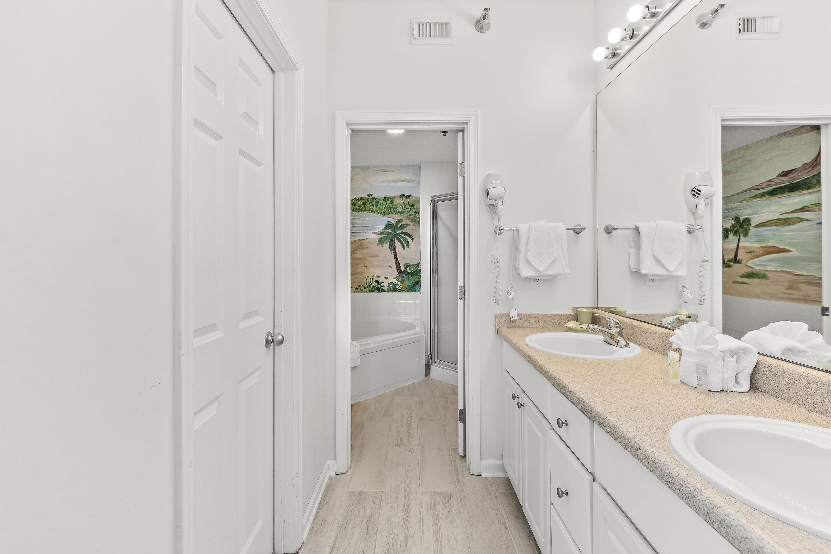 A modern bathroom with two sinks, a large mirror, and a shower.