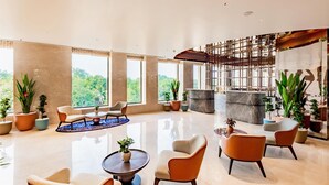 A spacious lobby with high ceilings, large windows, and a variety of seating arrangements.