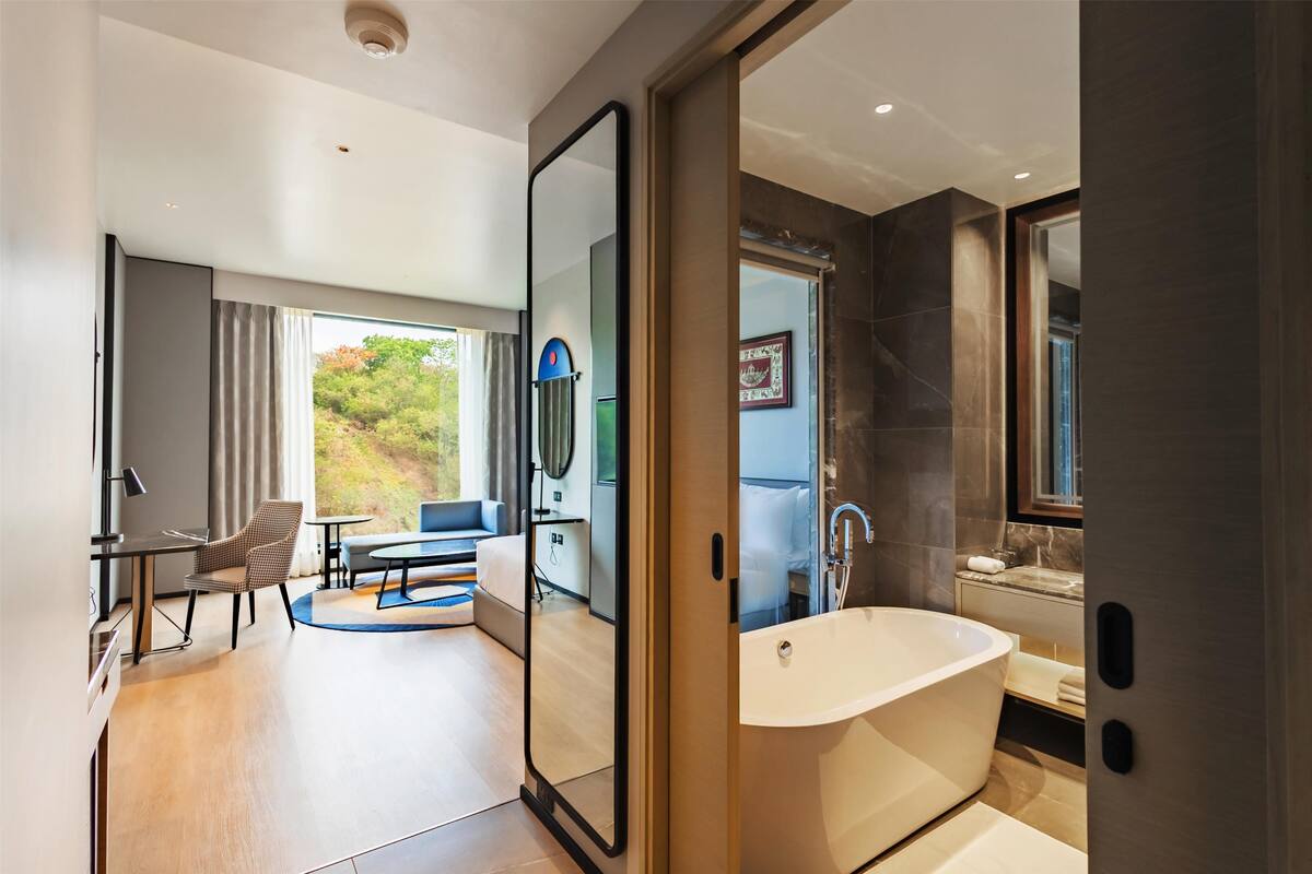 Un baño moderno con una bañera grande, un espejo y una zona de ducha.