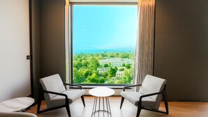 A modern room with a large window, two armchairs, and a small round table.