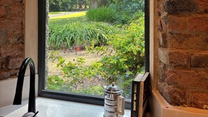 Une cuisine avec une fenêtre donnant sur un jardin.