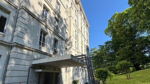 Ein klassizistisches Gebäude mit überdachter Eingangshalle, einer Steinfassade und einem gepflegten Rasen.