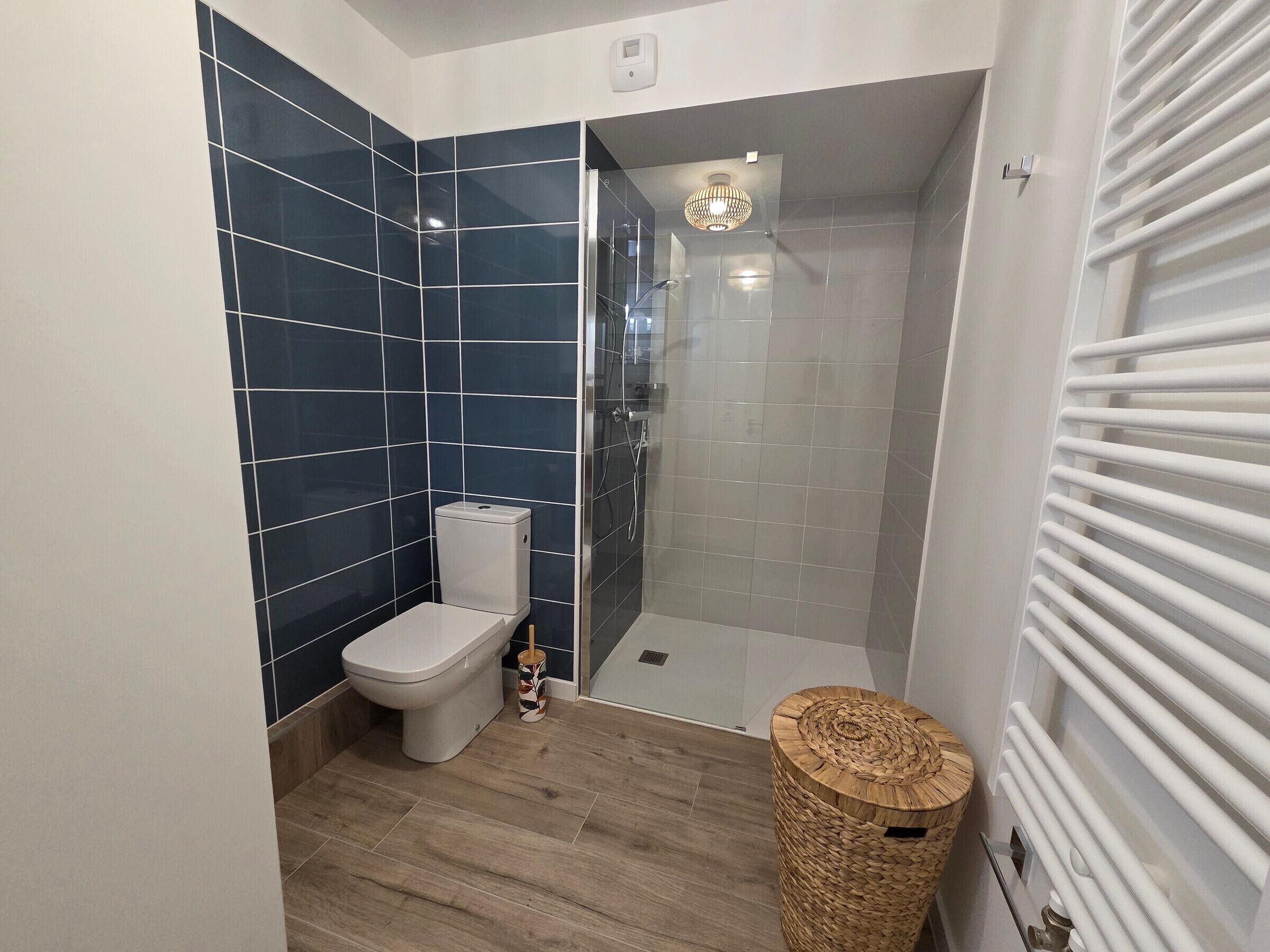 Ein Badezimmer mit Toilette, Dusche und Mülleimer.