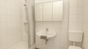 Ein Badezimmer mit Dusche, Waschbecken und Toilette.