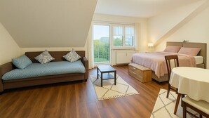 Et hyggeligt soveværelse med seng, et lille bord og en sofa.
