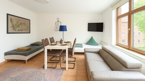 Un salon moderne avec une table à manger, un canapé et un téléviseur.