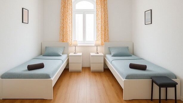 A twin bedroom with two single beds, a small table, a bench, and a window with curtains. - Apartment Halle city center - 3 rooms (Halle (Saale))