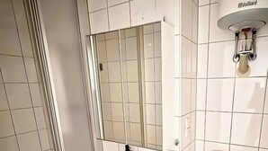 A modern bathroom with a shower, sink, and toilet. - Apartment Halle city center - 3 rooms (Halle (Saale))