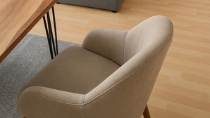 Une chambre moderne avec deux lits, une table en bois, une chaise beige et un tableau au mur.