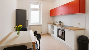 Une cuisine de taille réduite comprenant un coin repas, une fenêtre et un radiateur.