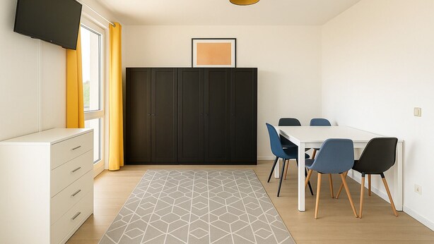 A modern room with a flat-screen TV, a black wardrobe, a dining table with chairs, and a patterned rug.