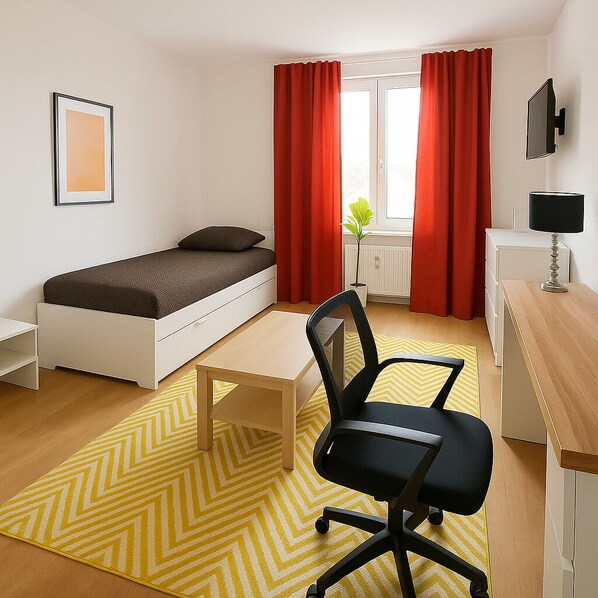 Une chambre à coucher de taille réduite, comprenant un lit simple, un bureau, une chaise et un téléviseur.