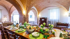 A dining area with a brick ceiling, arched alcoves, and a table set with plates, glasses, bread, and flowers. - Luxury Podere Forncacchia - Privacy, Exclusive View (Toscana)