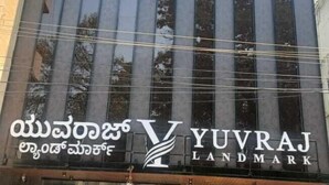 A modern building with a large glass facade and a sign for 'Yuvraj Landmark'. - Yuvraj Landmark (Mysore)