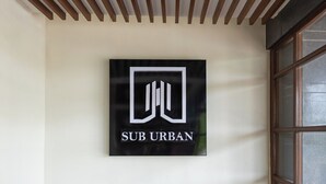 Un logo con il testo 'SUB URBAN' su una parete.