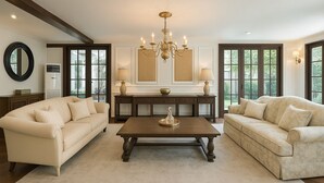A spacious living room with two beige sofas, a wooden coffee table, and a chandelier. - Colonial type 4-bedroom villa in Colombo with WiFi, AC (Colombo)
