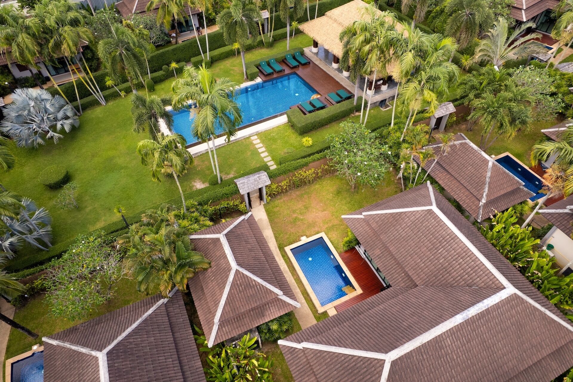 Un complexe hôtelier doté de plusieurs piscines, d’une végétation luxuriante et d’une architecture moderne.