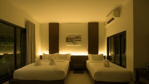 A hotel room with two beds, a large window, a painting on the wall, and an air conditioning unit. - Green Garden Villa Hotel (Rawai)