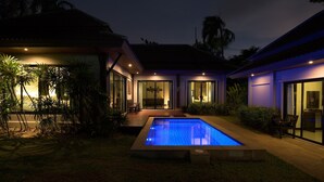 A modern house with a swimming pool, large glass doors, and a well-lit patio area. - Green Garden Villa Hotel (Rawai)