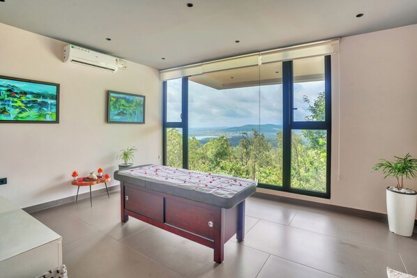 A modern room with a pool table, large windows with a city view, and two paintings on the wall. - Sila Secret Mirage (Mudigere)
