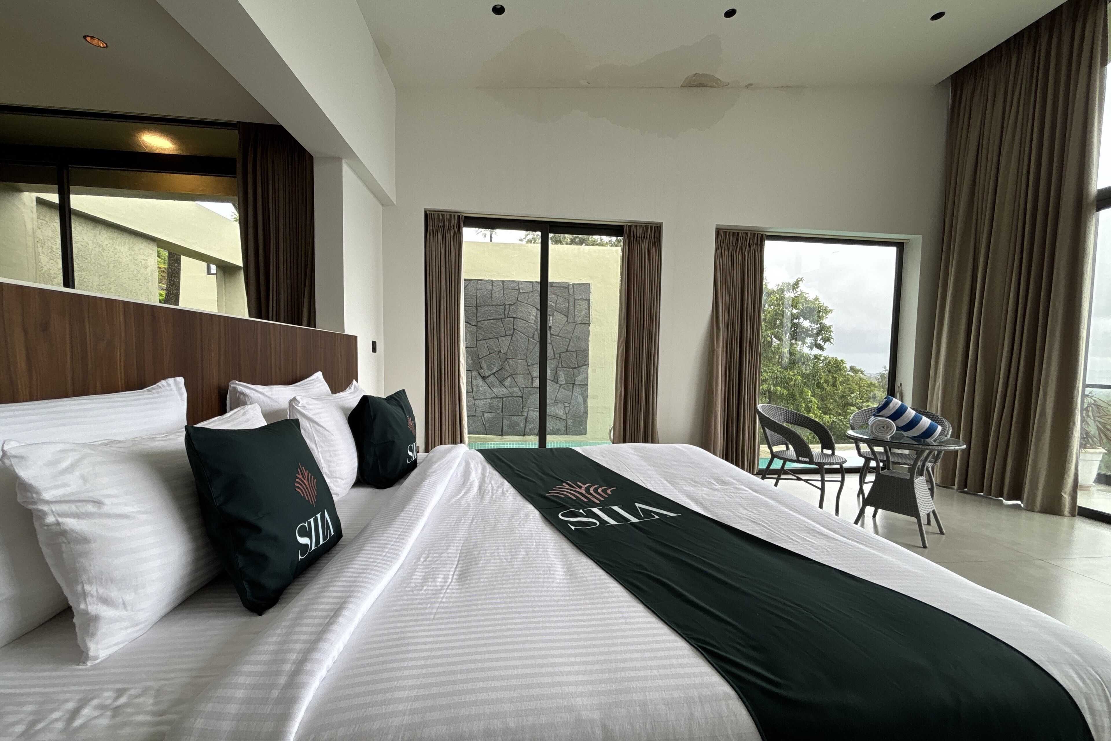 Une chambre d’hôtel moderne dotée d’un grand lit, d’un balcon avec vue et d’un coin repas avec des chaises.