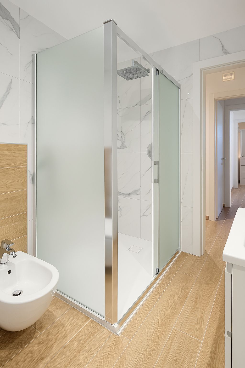Une salle de bain moderne avec une douche à l’italienne en verre, un meuble-lavabo en bois et un lavabo blanc.