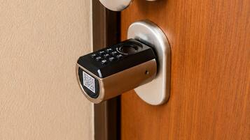 A door with a modern electronic lock and a round, metallic handle.