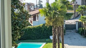 Une piscine entourée d’une pelouse bien entretenue et de palmiers.