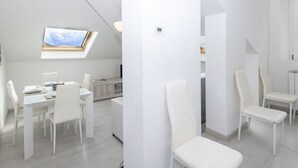 Un intérieur moderne et épuré, avec un espace repas, une cuisine et une salle de bain.