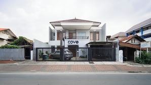 A two-story building with a 'cove' sign, a gated entrance, and a paved sidewalk.