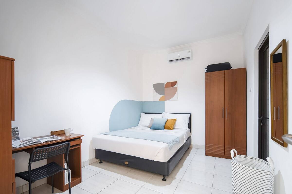 Un dormitorio con cama, escritorio, silla y armario.