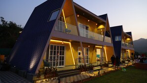 Un edificio moderno de varios pisos con un diseño triangular distintivo, con balcones y ventanas amplias.