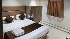 Ein modernes Schlafzimmer mit einem großen Bett, einem Holz-Kopfteil und einem Deckenventilator.