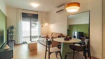 Apartamento, vistas a la ciudad | Zona de estar | Televisión de pantalla plana de 50 cm con canales por cable