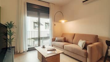 Apartamento, vistas a la ciudad | Zona de estar | Televisión de pantalla plana de 50 cm con canales por cable