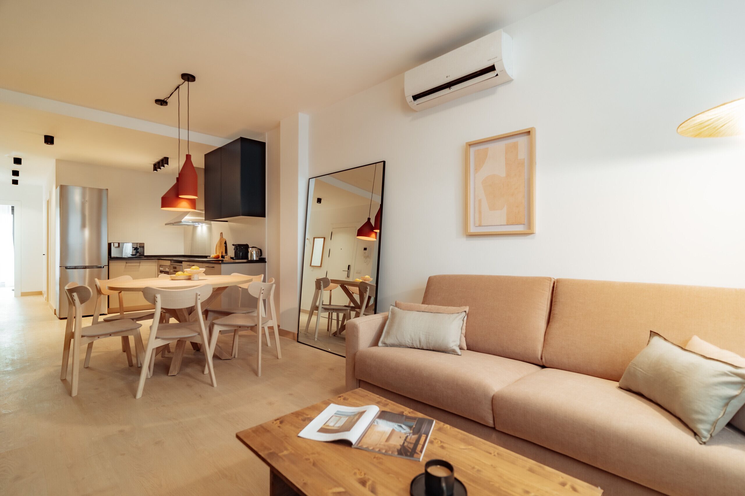 Uma sala de estar moderna com sofá, mesa de jantar, cadeiras e mesa de centro.