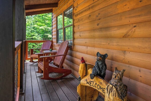 Eine Holzhütte mit Veranda, Schaukelstühlen und einem Willkommensschild.