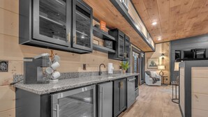 A modern kitchen with dark cabinetry, granite countertops, and stainless steel appliances. - 10BR Luxury | 2 Cabins | Rooftop Lounges | Indoor Pools | Hot Tubs | Walk to Water Park | Sleeps 44 (Sevierville)