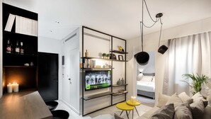 Een moderne woonkamer met een bank, een eettafel en een televisie bevestigd aan een zwart metalen frame.