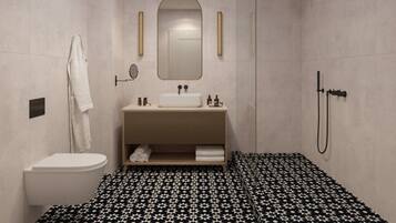 Un baño moderno con inodoro blanco, un lavabo con espejo superior, una ducha con cabezal de ducha manual y un piso estampado.