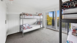 A bunk bed room with a basketball hoop, a window with a view of trees, and a balcony with a railing. - Panorama Dream (Aireys Inlet)