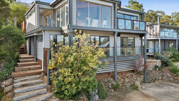 A modern two-story house with a stone foundation, a wooden staircase, and a well-maintained garden. - Panorama Dream (Aireys Inlet)