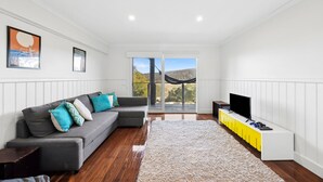A modern living room with a grey sofa, a flat-screen TV, and a yellow cabinet. - Panorama Dream (Aireys Inlet)