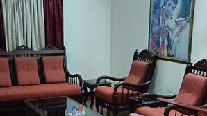 A living room with a sofa set, a coffee table, and a painting on the wall.