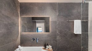 A modern bathroom with a large rectangular sink, two faucets, a mirror, and a glass shower enclosure. - 2BD Luxury Sea View Penthouse in Astir Beach (Vouliagmeni)
