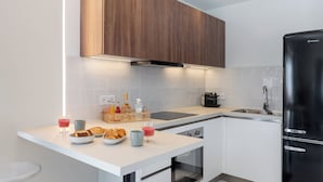 A modern kitchen with a white countertop, wooden cabinets, a black refrigerator, and a built-in oven. - 2BD Luxury Sea View Penthouse in Astir Beach (Vouliagmeni)